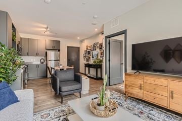 Fort Collins apartment for rent - A modern living room with a grey sofa and a wooden cabinet.