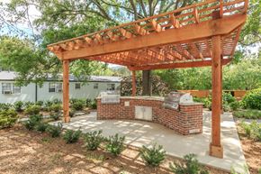 Atlanta apartment for rent - a backyard with a brick barbecue and a wooden pergola