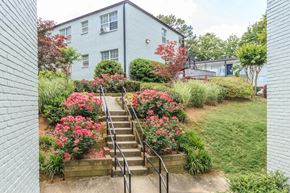 Atlanta apartment for rent - a staircase leading up to a blue house with pink flowers in front of it