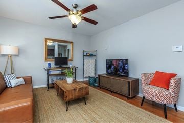 Atlanta apartment for rent - a living room with a couch and a tv and a ceiling fan