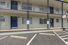 Atlanta apartment for rent - a building with blue doors and windows and a parking lot in front of it