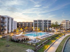 Houston apartment for rent - A modern apartment complex with a pool and a walking path.