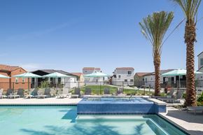 Casa Grande townhouse for rent - A swimming pool surrounded by palm trees and lounge chairs.