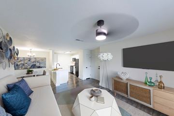 Jacksonville apartment for rent - A modern living room with a white sofa and a large painting on the wall.