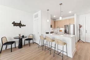 San Antonio apartment for rent - A kitchen with a white counter and black chairs.