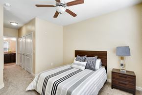 Austin apartment for rent - the master bedroom has a large bed and a ceiling fan