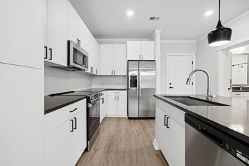 Charlotte apartment for rent - A modern kitchen with white cabinets and stainless steel appliances.