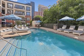Austin apartment for rent - A swimming pool with a metal ladder and sun loungers.