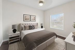 Austin apartment for rent - A bedroom with a large bed and a nightstand with a lamp.