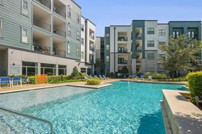 Dallas apartment for rent - A swimming pool in front of apartment buildings.