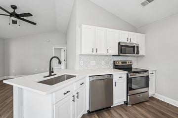 Aberdeen townhouse for rent - A modern kitchen with white cabinets and stainless steel appliances.