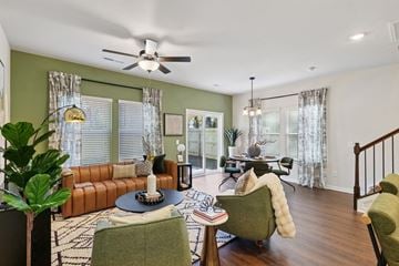 Charlotte townhouse for rent - A living room with a brown leather couch, a green armchair, and a round table with a candle on it.