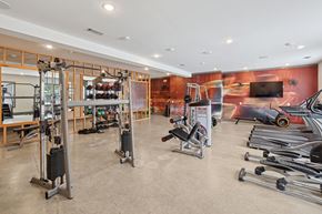 Charlotte apartment for rent - A gym with a variety of equipment including weights and a bench press.