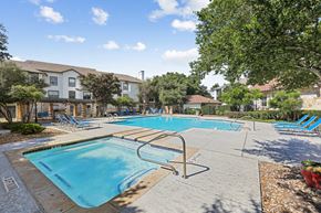 Austin apartment for rent - A large swimming pool surrounded by trees and chairs.