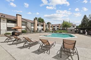 Rocklin apartment for rent - A pool surrounded by chairs and buildings.