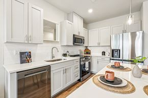 Brighton townhouse for rent - A modern kitchen with white cabinets and stainless steel appliances.