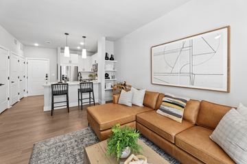 Austin apartment for rent - A living room with a brown leather couch and a large abstract painting on the wall.