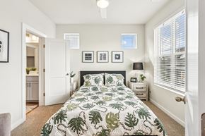Brighton townhouse for rent - A bedroom with a large bed and a green leaf patterned comforter.