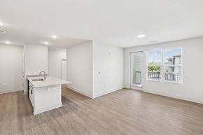 Charlotte apartment for rent - A white kitchen with a sink and a window overlooking a cityscape.