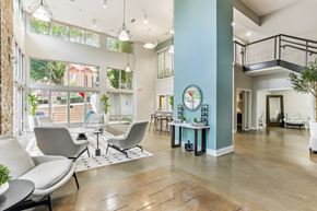 Atlanta apartment for rent - A spacious waiting area with grey chairs and a wooden floor.