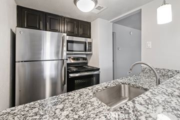 Dallas apartment for rent - A kitchen with a stainless steel refrigerator and microwave.