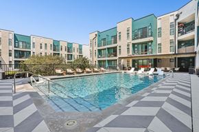 Austin apartment for rent - A swimming pool in front of a building with a black and white checkered floor.