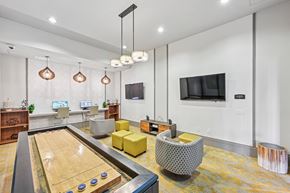 Orlando apartment for rent - A shiny pool table is in the middle of a room with a yellow chair and a television.