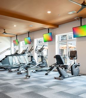 Cincinnati apartment for rent - A gym with a row of exercise bikes and a fan.
