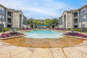 Houston apartment for rent - a large swimming pool with an apartment building in the background