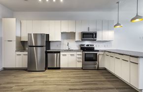 Austin apartment for rent - a kitchen with white cabinets and stainless steel appliances