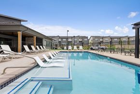 Denver townhouse for rent - A swimming pool with lounge chairs and a fence in the background.