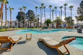 Henderson apartment for rent - a pool with lounge chairs and palm trees in the background