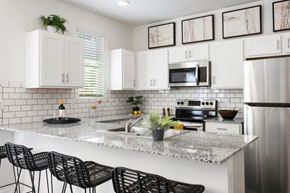 Surprise townhouse for rent - a kitchen with white cabinets and a marble counter top