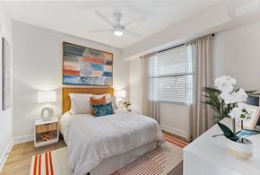 Cape Coral apartment for rent - A bedroom with a bed, a ceiling fan, and a painting on the wall.