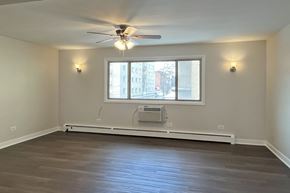 Forest Park apartment for rent - A room with a ceiling fan and a window with a view of a street.