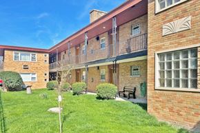 Oak Park apartment for rent - a brick apartment building with a green yard and a bench