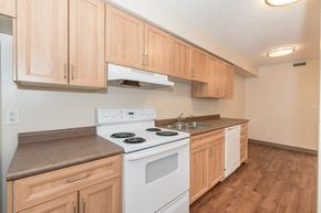 Waterloo apartment for rent - A kitchen with wooden cabinets and a white stove top oven.