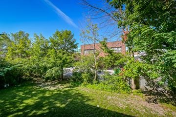 Waterloo apartment for rent - A lush green garden with a building in the background.