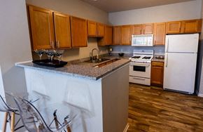 Merrillville apartment for rent - A kitchen with wooden cabinets and a white fridge.