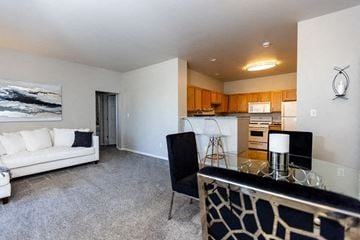 Merrillville apartment for rent - A living room with a white couch and a black and white patterned couch.