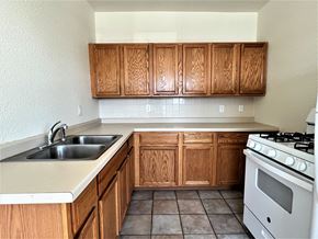 St Paul apartment for rent - a kitchen with wooden cabinets and white appliances