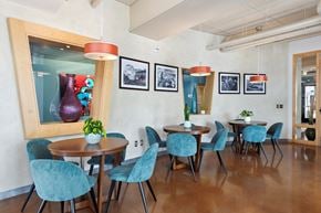 St Paul apartment for rent - a dining room with blue chairs and a large red vase on the wall