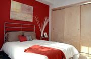St Paul apartment for rent - a bedroom with a red wall and a white bed
