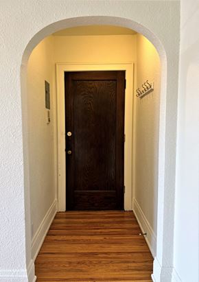 St Paul apartment for rent - a hallway with a wooden door and an arched doorway