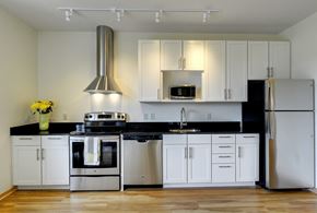 Minneapolis apartment for rent - Flat J, 1 bedroom floor plan at Coze Flats, kitchen with white cabinets, stainless steel appliances and black granite countertops