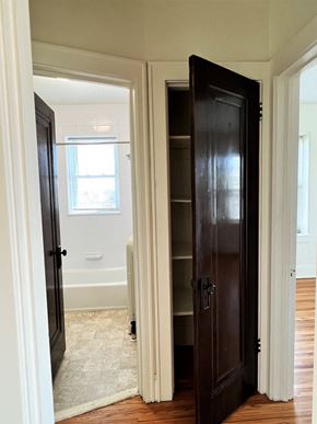 St Paul apartment for rent - a closet in a bedroom with a door open to a bathroom with a tub and a window