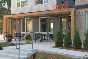 St Paul apartment for rent - the entrance to coze flats with tables and chairs outside of the building