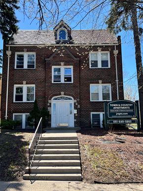 St Paul apartment for rent - a large brick building with a white door and a sign in front of it