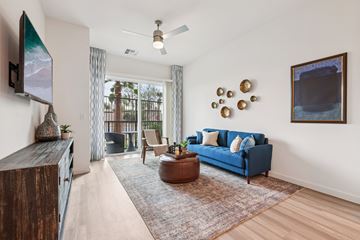 Las Vegas apartment for rent - A living room with a blue couch and a flat screen TV mounted on the wall.