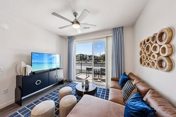 Las Vegas apartment for rent - A living room with a brown couch and a television on a cabinet.